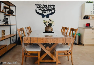 שולחן עץ גדול עם שישה כיסאות בפינת אוכל מעוצבת במתחם אירוח בגליל העליון (צילום: יחצ)