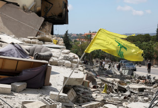 דגל חיזבאללה על רקע הרס בלבנון (צילום: REUTERS/Aziz Taher)