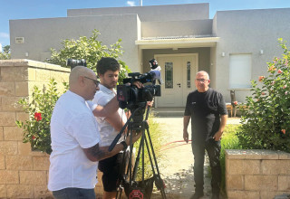 שמעון אלקבץ על רקע ביתו בכפר עזה (צילום: פרטי)