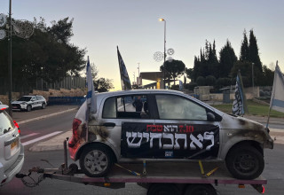 מייצג מכוניות שרופות מול הכנסת (צילום: אורנה קופרמן)