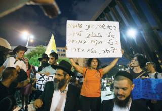 אישה מפגינה ליד אירוע "משיח בכיכר" (צילום:  דוד כהן, פלאש 90)