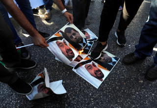 פלסטינים שורפים את תמונותיהם של בן זאיד ודחלאן במחאה על ההסכם בין ישראל לאיחוד האמירויות (צילום:  REUTERS/Mohamad Torokman)