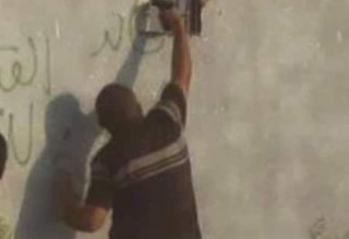 מפגין פלסטיני מכוון אקדח דרך גדר רצועת עזה (צילום:  ללא)
