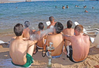 בני נוער מעשנים נרגילות בחוף הים באילת (צילום: יהודה בן יתח)