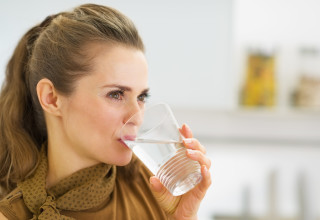 אישה שותה מים (צילום: אינג אימג')