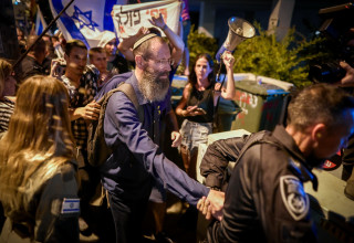 הרב יגאל לוינשטיין מוקף מפגינים בתל אביב (צילום: אבשלום ששוני)