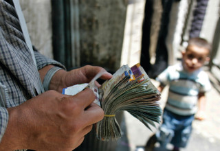 מחליף מטבעות פלסטיני סופר כסף ברחוב ברמאללה  (צילום:  רויטרס)