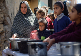 פלסטינים מחכים לקבלת מזון בעיר האוהלים ברפיח (צילום:  רויטרס)
