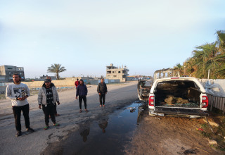 עזתים עומדים ליד רכב ארגון הסיוע שנפגע השבוע בעזה  (צילום:  רויטרס)
