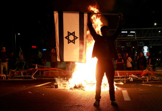 מפגין על איילון לאחר פיטורי יואב גלנט, נובמבר 2024 (צילום: רויטרס)