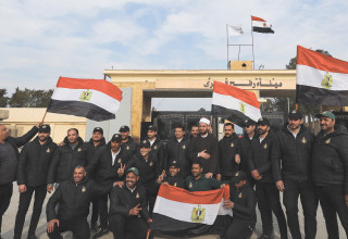 ושבי רצועת עזה ושוטרים מצרים מניפים דגלי מצרים במעבר רפיח (צילום: רויטרס)