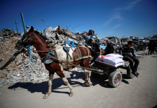 תושבי רצועת עזה עם הסיוע ההומניטרי (צילום: REUTERS/Mahmoud Issa)