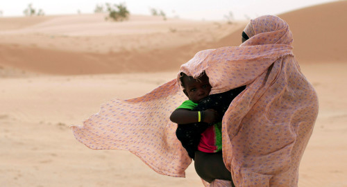 אישה מגנה על בנה מפני הרוח במאוריטניה, מערב אפריקה  (צילום: רויטרס)