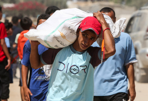 פלסטיני סוחב סיוע הומניטרי (צילום: רויטרס)