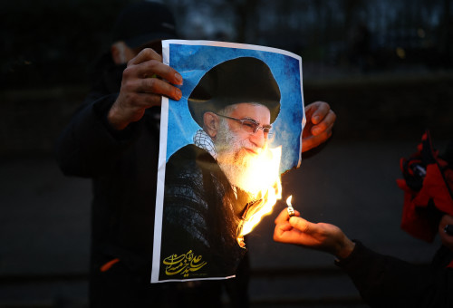 תמונתו של חמינאי עולה באש (צילום: HENRY NICHOLLS / AFP via Getty Images)