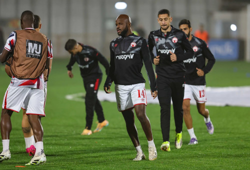 ג'בון איסט שחקן הפועל באר שבע בחימום, מאחוריו מוחמד אבו רומי (צילום: לירון מולדובן)