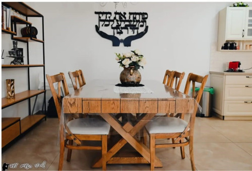 שולחן עץ גדול עם שישה כיסאות בפינת אוכל מעוצבת במתחם אירוח בגליל העליון (צילום: יחצ)