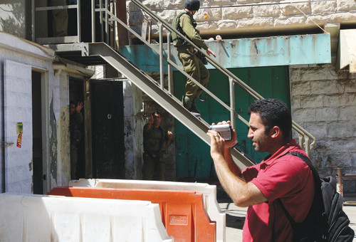 פעיל בצלם, חברון (צילום: רויטרס)