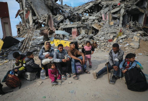 משפחה פלסטינית ליד הריסות ביתה בעזה (צילום: רויטרס)