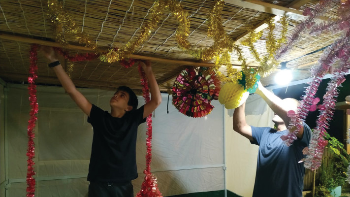 תליית קישוטים בסוכה