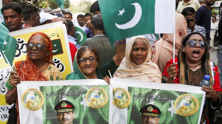 נשים ברחובות מחזיקים בשלט עם תמונתו של מפקד צבא פקיסטן, אסים מוניר