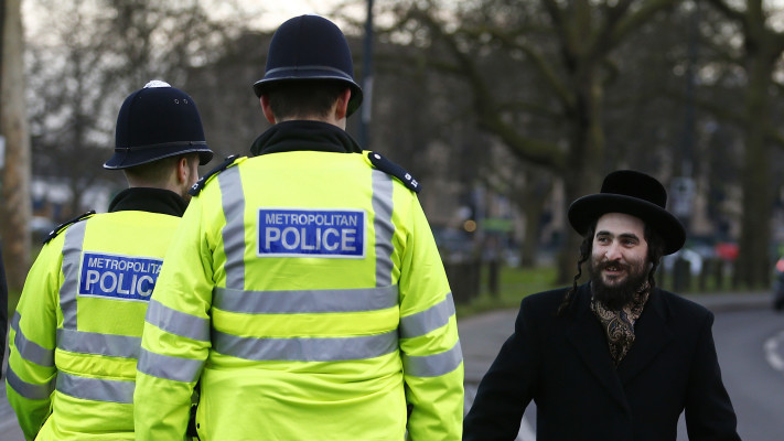 יהודי הולך ברחובות לונדון ליד המשטרה המקומית