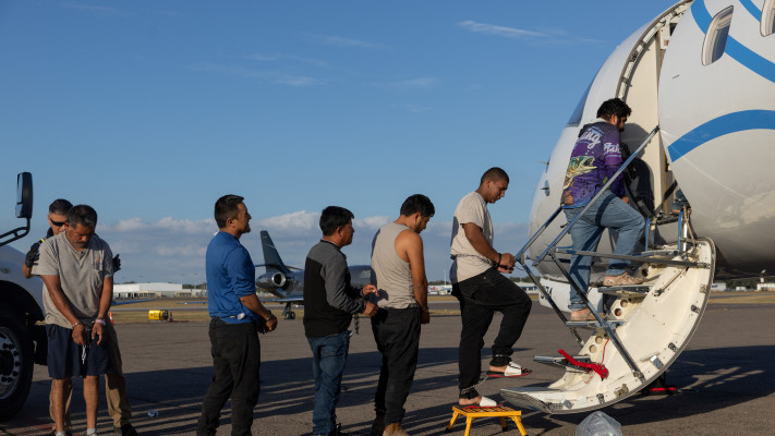 מהגרים מועלים על מטוס 