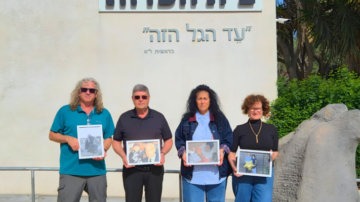 המדריכים בכניסה לבית העדות - מחזיקים בתמונות הוריהם שורדי השואה