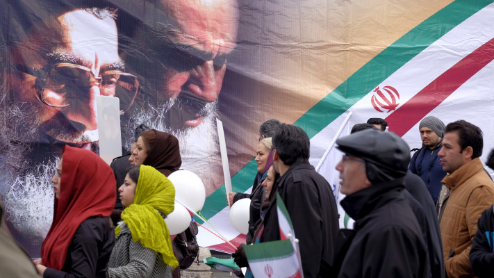איראנים מול כרזות של חומייני וחמנאי בטהרן (צילום: רויטרס)