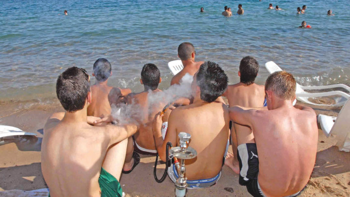 בני נוער מעשנים נרגילות בחוף הים