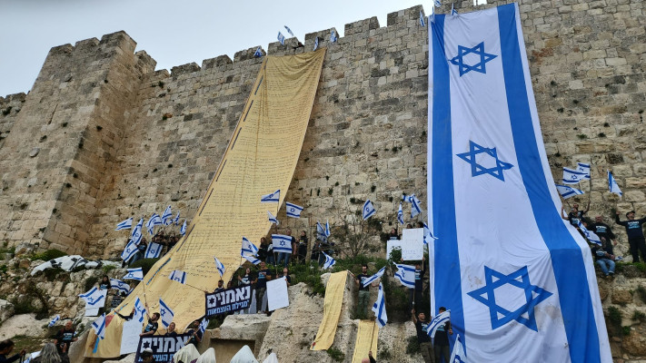 דגל ישראל ומגילת העצמאות נתלו על חומות העיר העתיקה (צילום: מטה המאבק)