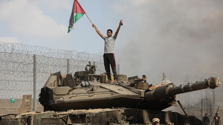 פלסטיני מניף דגל אש''ף מעל טנק ישראלי (צילום: יוסוף מוחמד, פלאש 90)