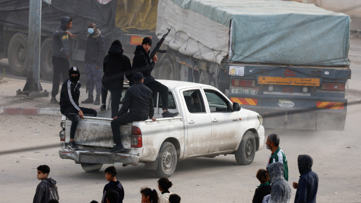 חמושים משתלטים על משאיות סיוע בעזה (צילום: REUTERS/Mohammed Salem)