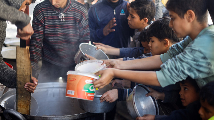 ילדים פלסטינים מחכים לקבלת מזון בעיר האוהלים ברפיח (צילום: רויטרס)