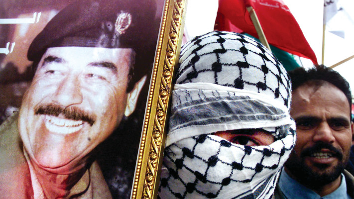 פלסטיני אוחז תמונה של סדאם חוסיין בהפגנה פרו עיראקית (צילום: רויטרס)