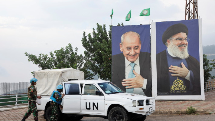 רכב של האו''ם סמוך לתמונה של נסראללה בלבנון (צילום: REUTERS/Mohamed Azakir)