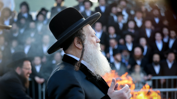 הרב רבי שאול טאוב מדליק מדורה במהלך ל''ג בעומר במירון (צילום: דוד כהן, פלאש 90)
