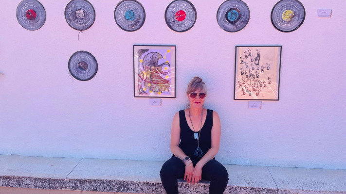 גיל ליבני שלומי על רקע חלק מיצירותיה