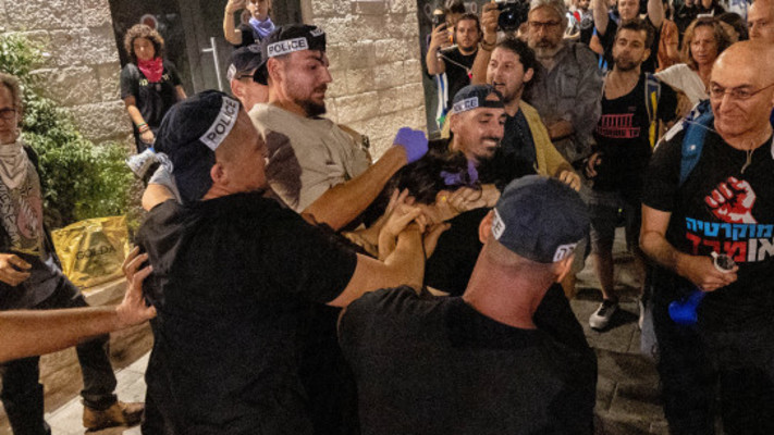 ארבעה שוטרים עוצרים מפגינה במחאה נגד הממשלה בירושלים