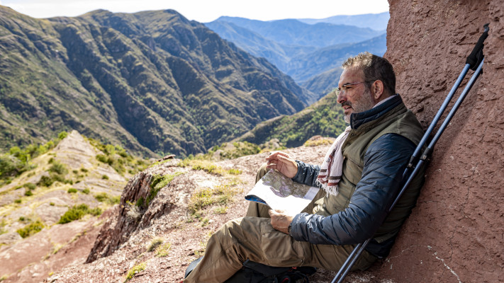 עם מפה ומקלות הליכה בידו
