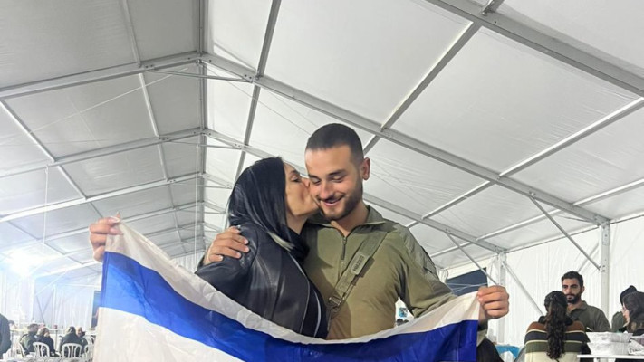 ניתאי ואימו אוחזים בדגל ישראל