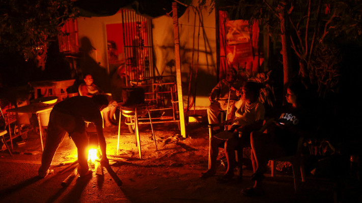 תושבי מקסיקו מבשלים מחוץ לביתם, לאחר פגיעת הוריקן בריל