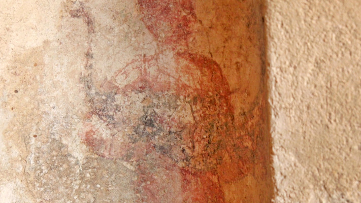 דמות אוחזת בטווס לפני עבודות השימור