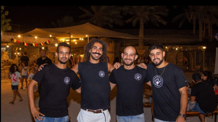 עודאי קורשאן עם צוות העובדים בכפר (צילום: באדיבות כפר הנוקדים)