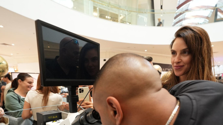 איתי לוי בודק את שבב התנ''ך שבתכשיט בעדשת המיקרוסקופ