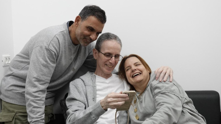 אוהד בן-עמי במפגש הראשון עם בני משפחתו, עם אשתו רז ואחיו קובי, בנקודת הקליטה הראשונית בישראל. (צילום: דובר צהל)