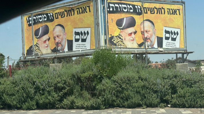 \'\'מבטיחים עזרה לחלשים, בפועל - מקבלים דגים סרוחים\'\'. שלטי ש''ס בכניסה לקריית שמונה (צילום: בתיה גלעדי)
