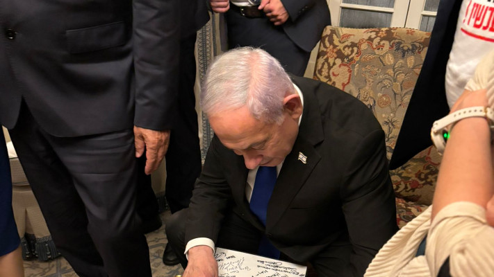בנימין נתניהו חותם על הפוסטר של איתי חן (צילום: ללא)