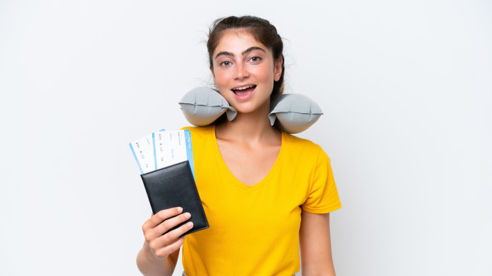 אישה עם כרית נסיעות מתנפחת וכרטיסי טיסה