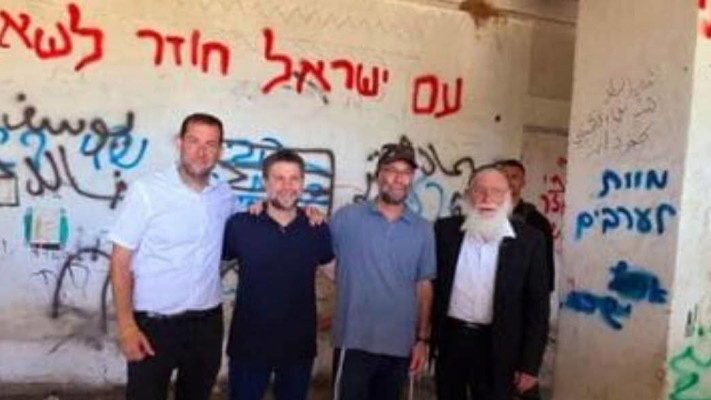 שר האוצר בצלאל סמוטריץ' מצטלם עם הגרפיטי ''מוות לערבים'' (צילום: לשכת שר האוצר)